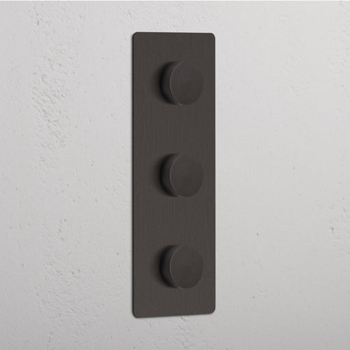 Triple 3x Vertical Multiway Dimmer Switch in bronze with three round knobs, mounted on a white wall.